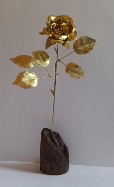 Rose en laiton. Pied en bois flotté teinté. Hauteur 47 cm